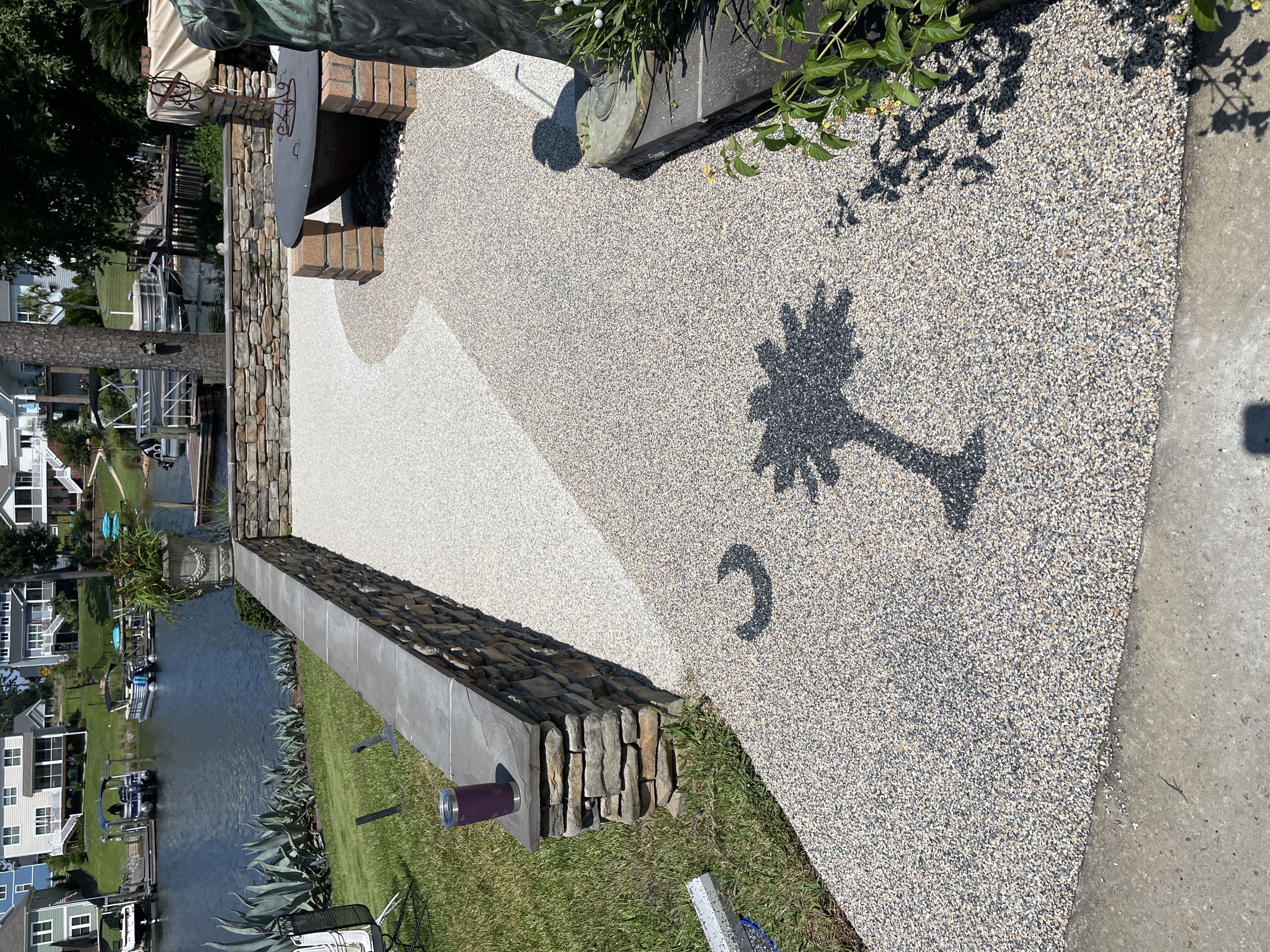 Lakefront resin rock patio with palmetto moon design and stone wall