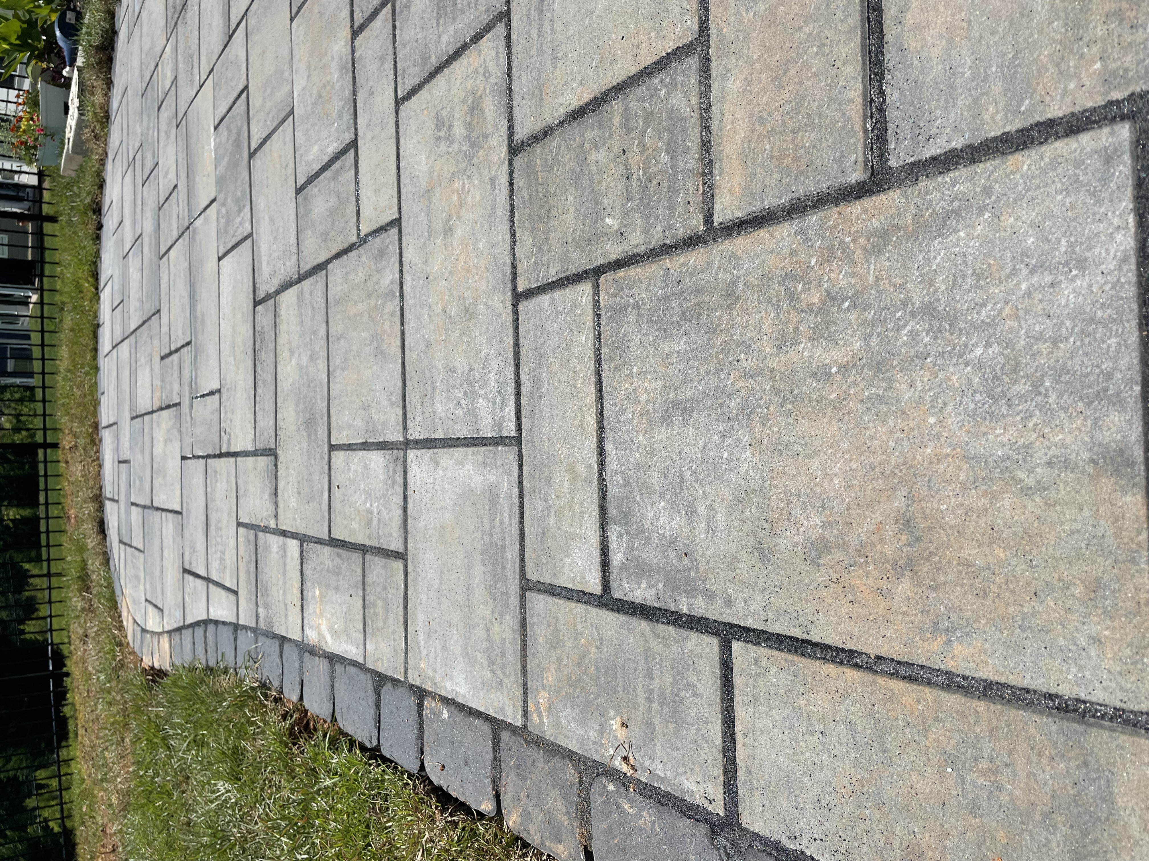 Large format paver patio with cobblestone border close-up