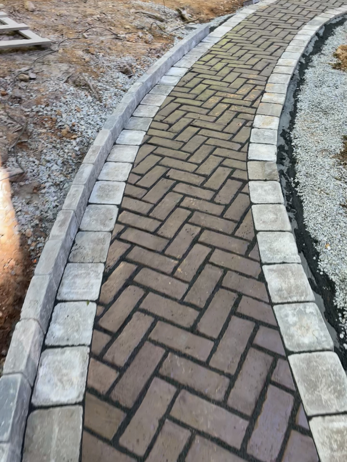 Herringbone paver walkway with stone border
