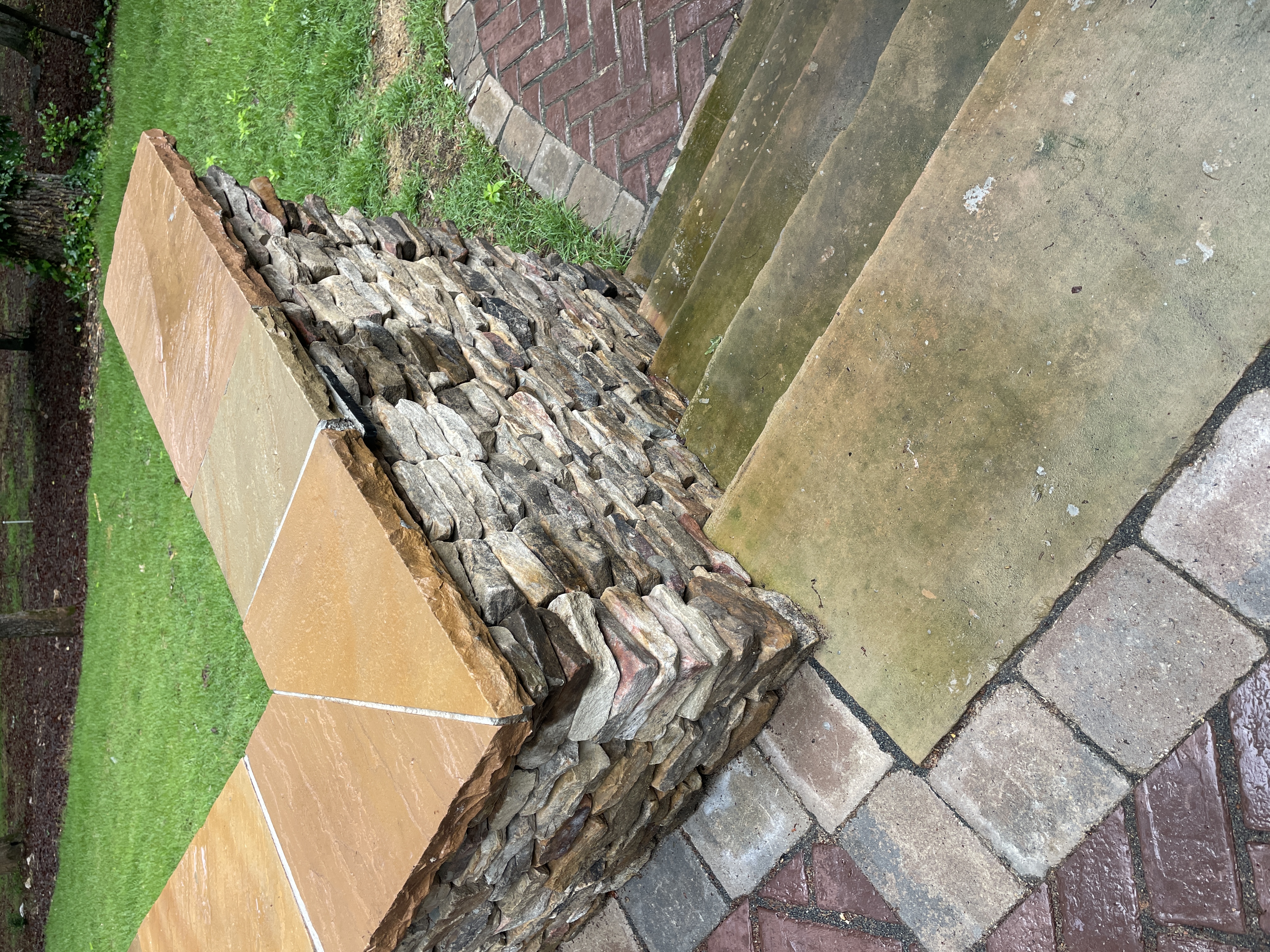 Stacked stone retaining wall with flagstone cap