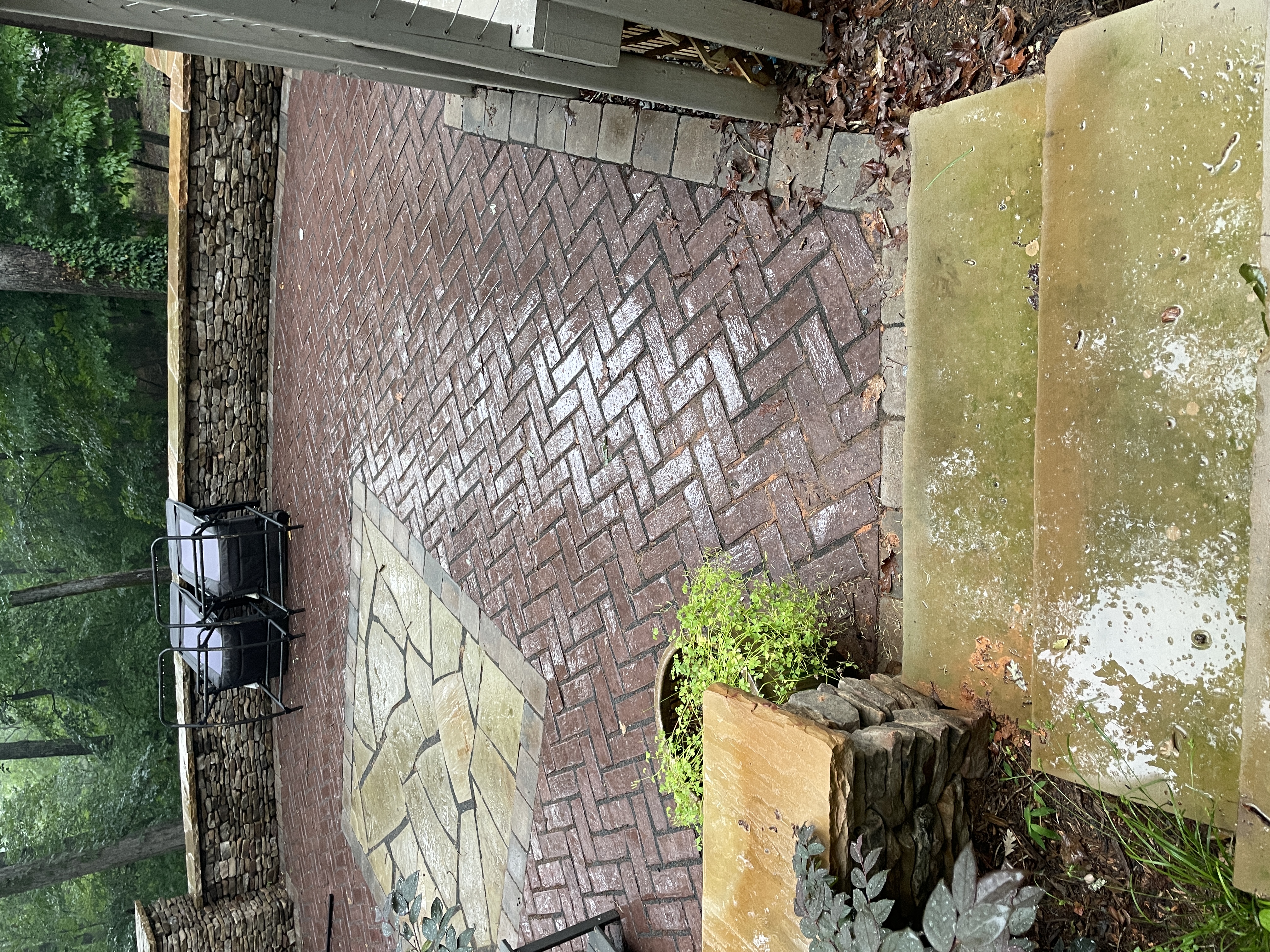 Stone retaining wall with herringbone brick patio